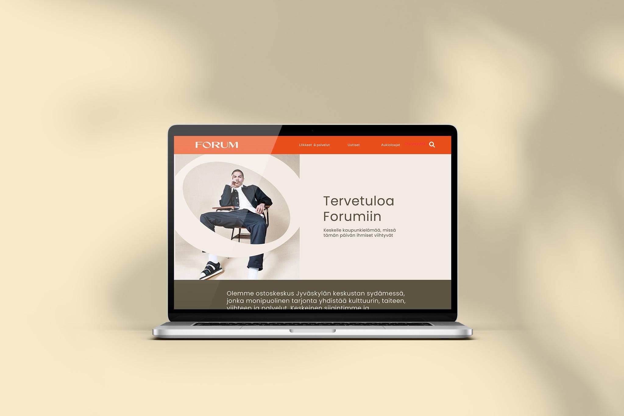 Kannettava tietokone näyttää esimerkin Kauppakeskus Forumin uudistetusta verkkosivuston etusivusta, jossa näkyy Forumin logo, navigaatio ja mainoskuva.